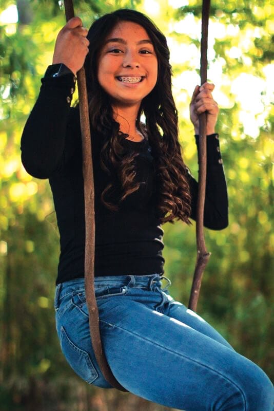 Image of teen girl swinging on a swing set